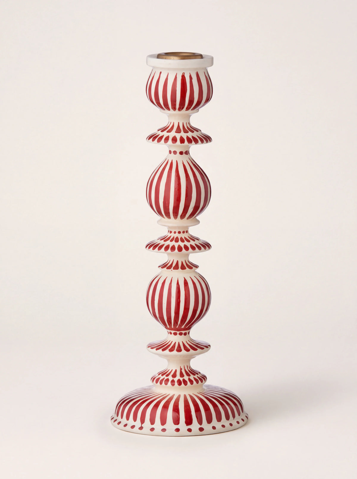 Turned wooden candle holder with red and white painted stripes, bulbous tiers and a metal insert