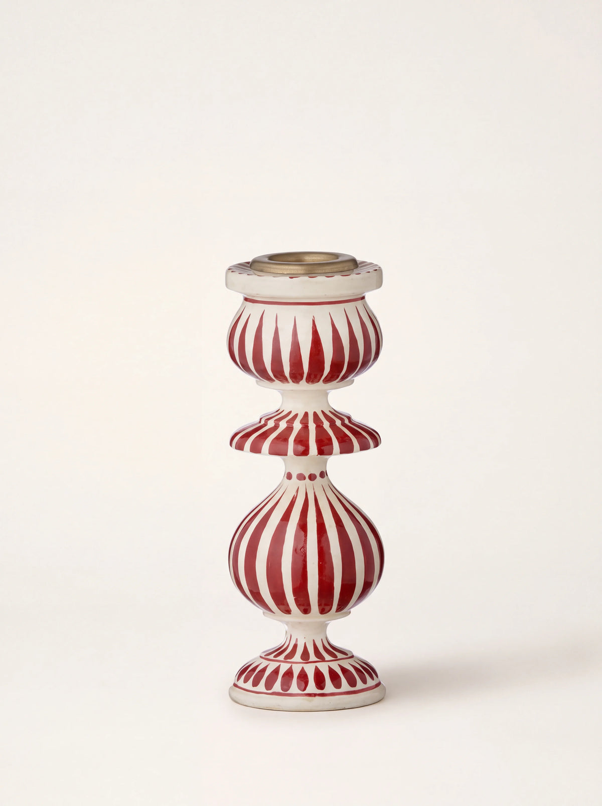 Turned wooden candle holder with painted red stripes on white and a metal insert at the top