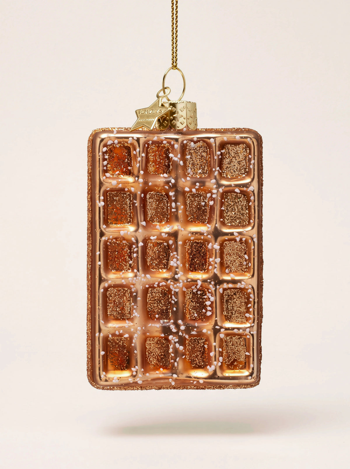 Glass sugar waffle ornament in golden brown with a glitter-filled grid, white sugar specks, and a hanging loop