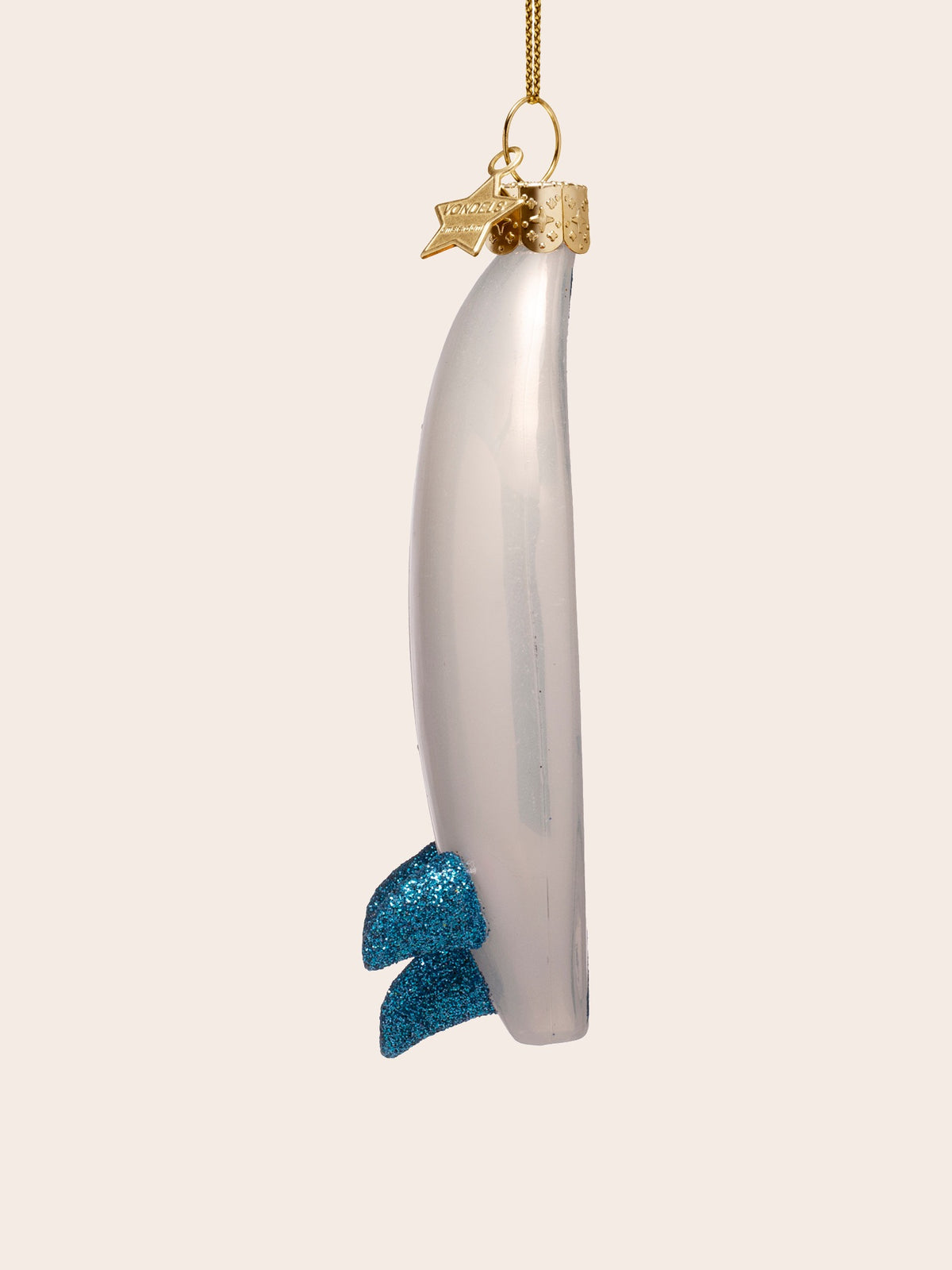 Side profile of the glass surfboard ornament highlighting its curved shape and rear fins