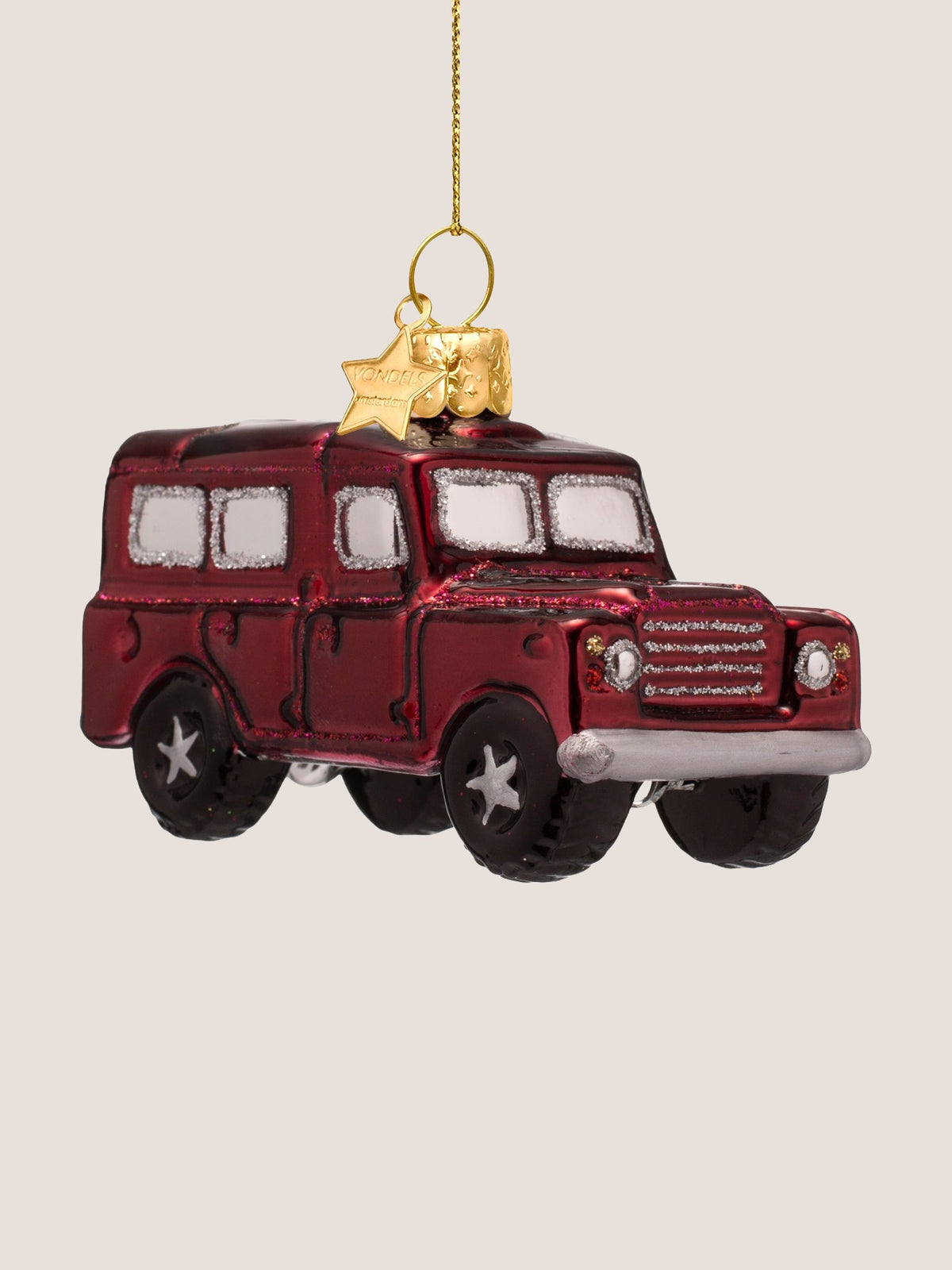 Three-quarter front view of the glass SUV ornament showing the silver bumper, headlights and glitter grille