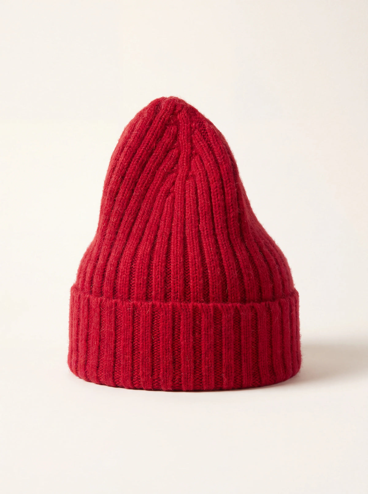 Tall ribbed wool beanie in raspberry red with a wide turn-up cuff