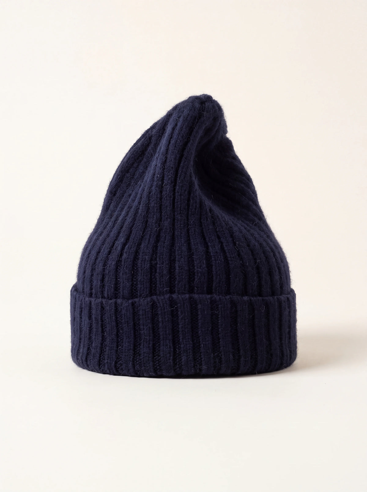 Midnight blue tall ribbed wool beanie with a wide folded cuff and elongated crown