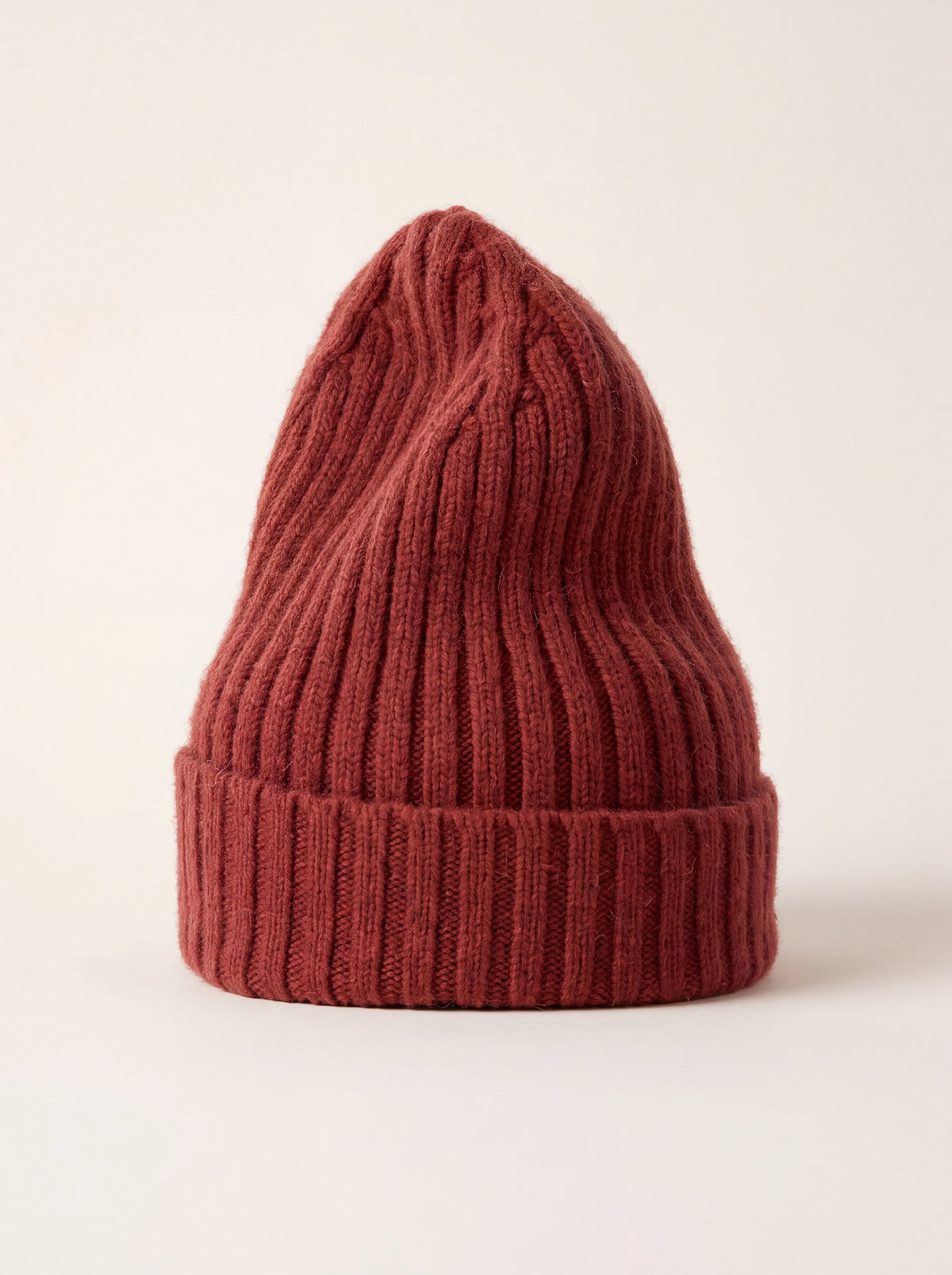 Tall ribbed wool beanie in terracotta red with a wide turn-up cuff