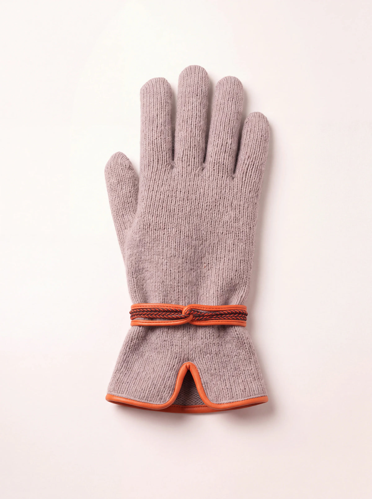 Taupe knitted wool and cashmere glove with orange leather piping at the notched cuff and a braided wrist strap