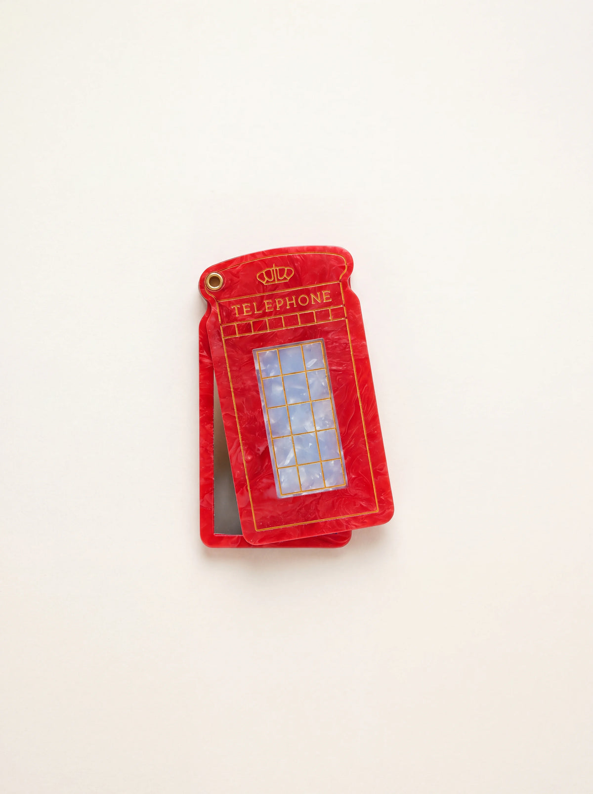 Marbled red cellulose acetate compact mirror shaped like a telephone box, swivelled slightly open