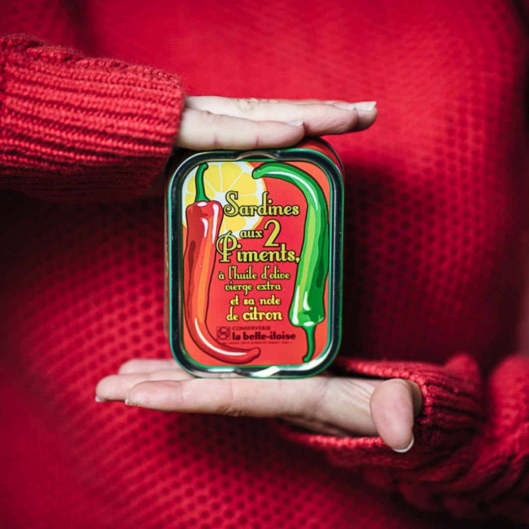 Tin of two-chilli and lemon sardines held between two hands to show its scale