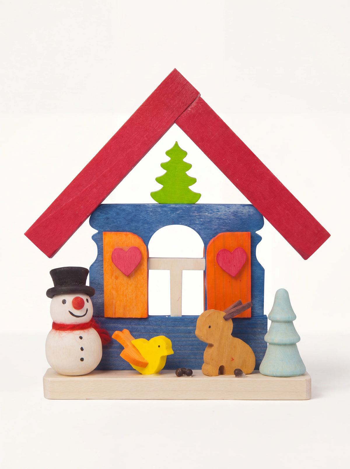 Wooden deer, yellow bird and pale blue tree figures standing on the ornament base beneath the window