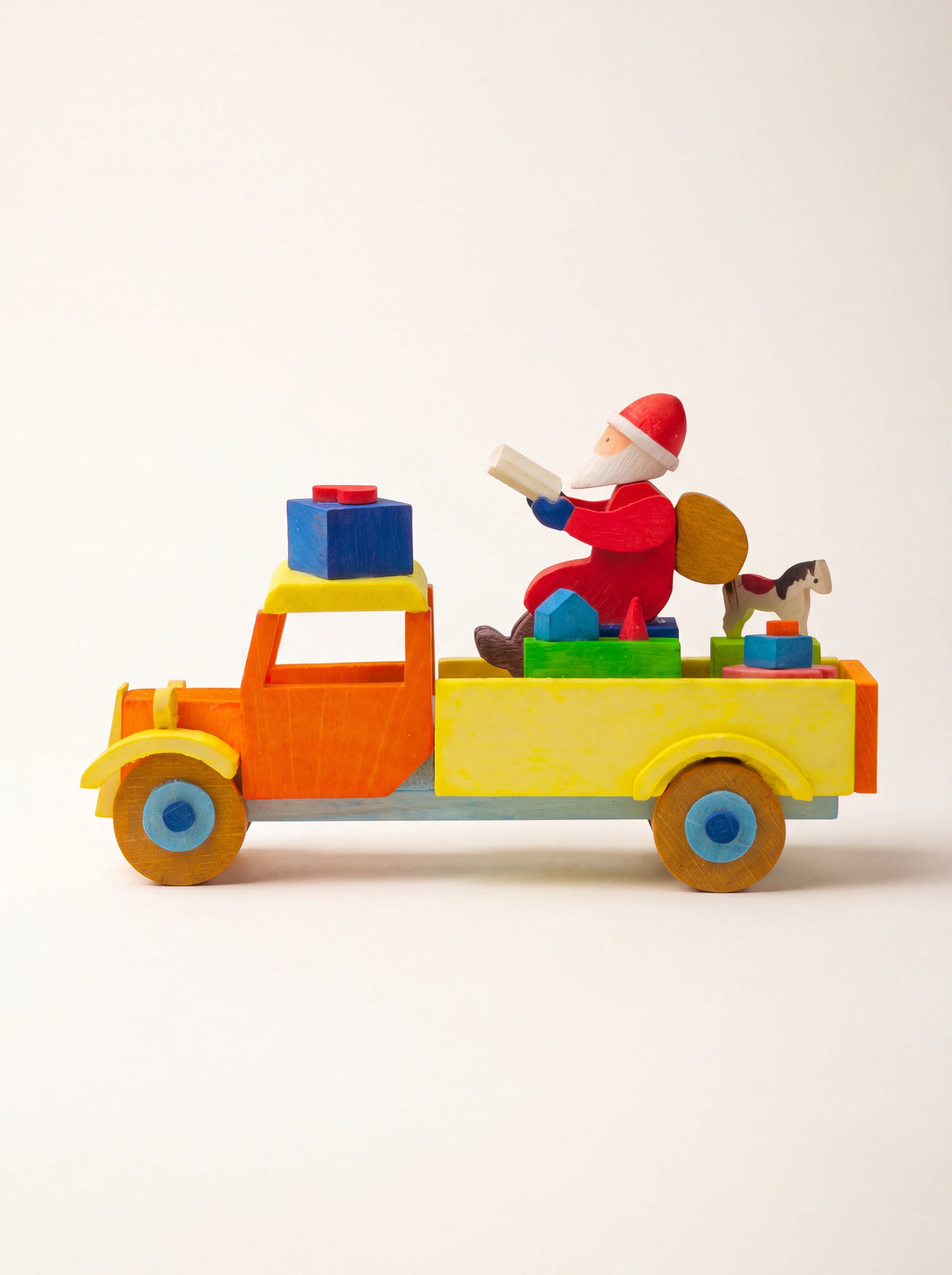 Painted maple wood truck ornament in orange and yellow, carrying Santa Claus, gifts and a toy horse