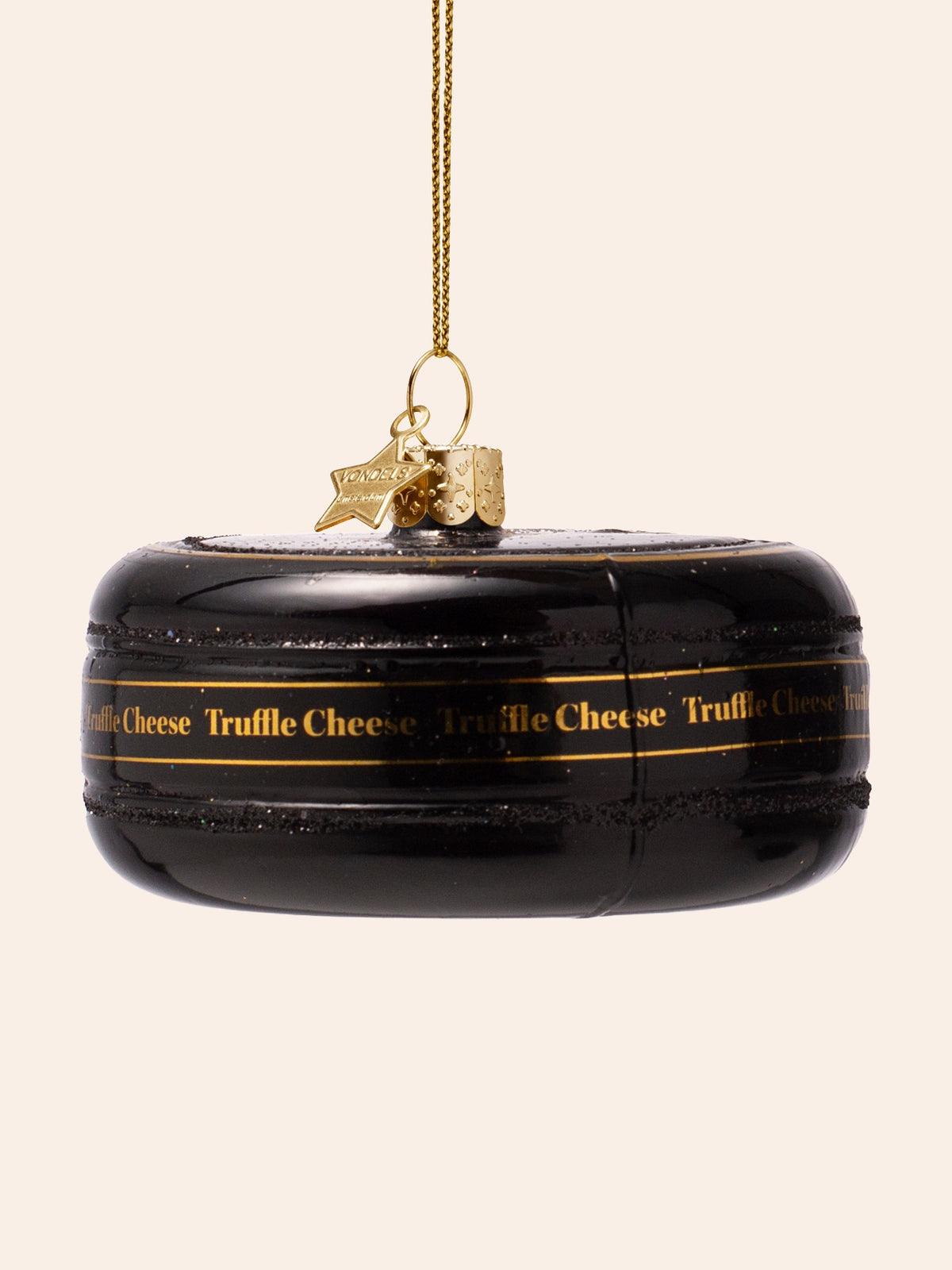 Back of the ornament showing the uncut black cheese wheel with repeated gold Truffle Cheese lettering