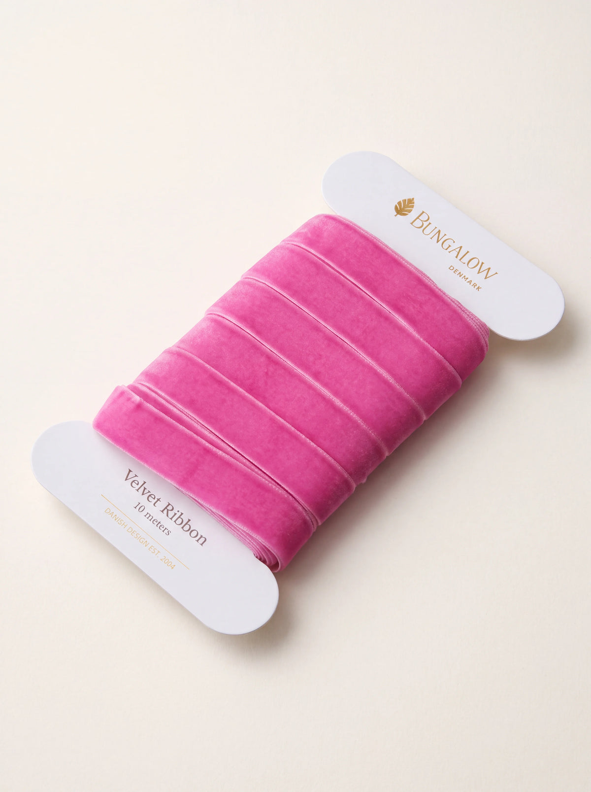 Azalea pink velvet ribbon wound around a white card spool labelled 10 meters