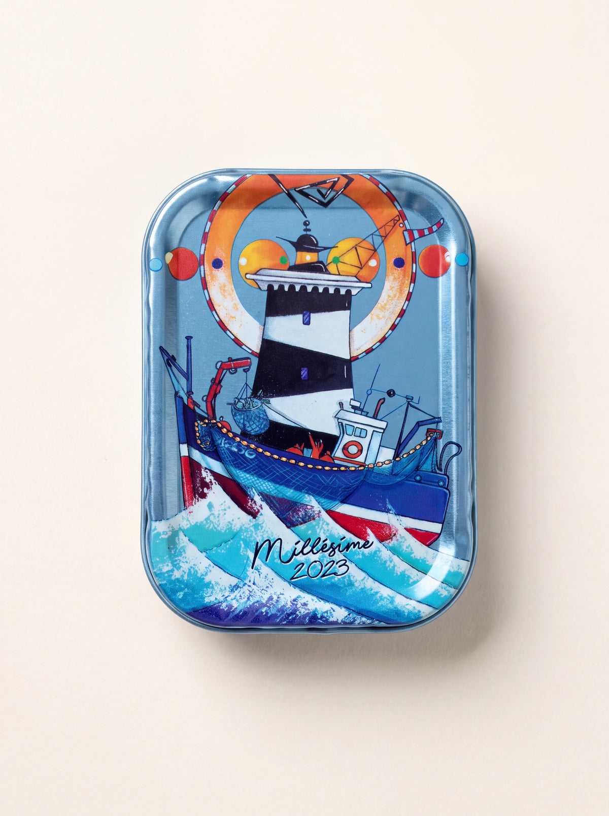 Sardine tin illustrated with a black-and-white lighthouse behind a fishing boat, inscribed Millésime 2023