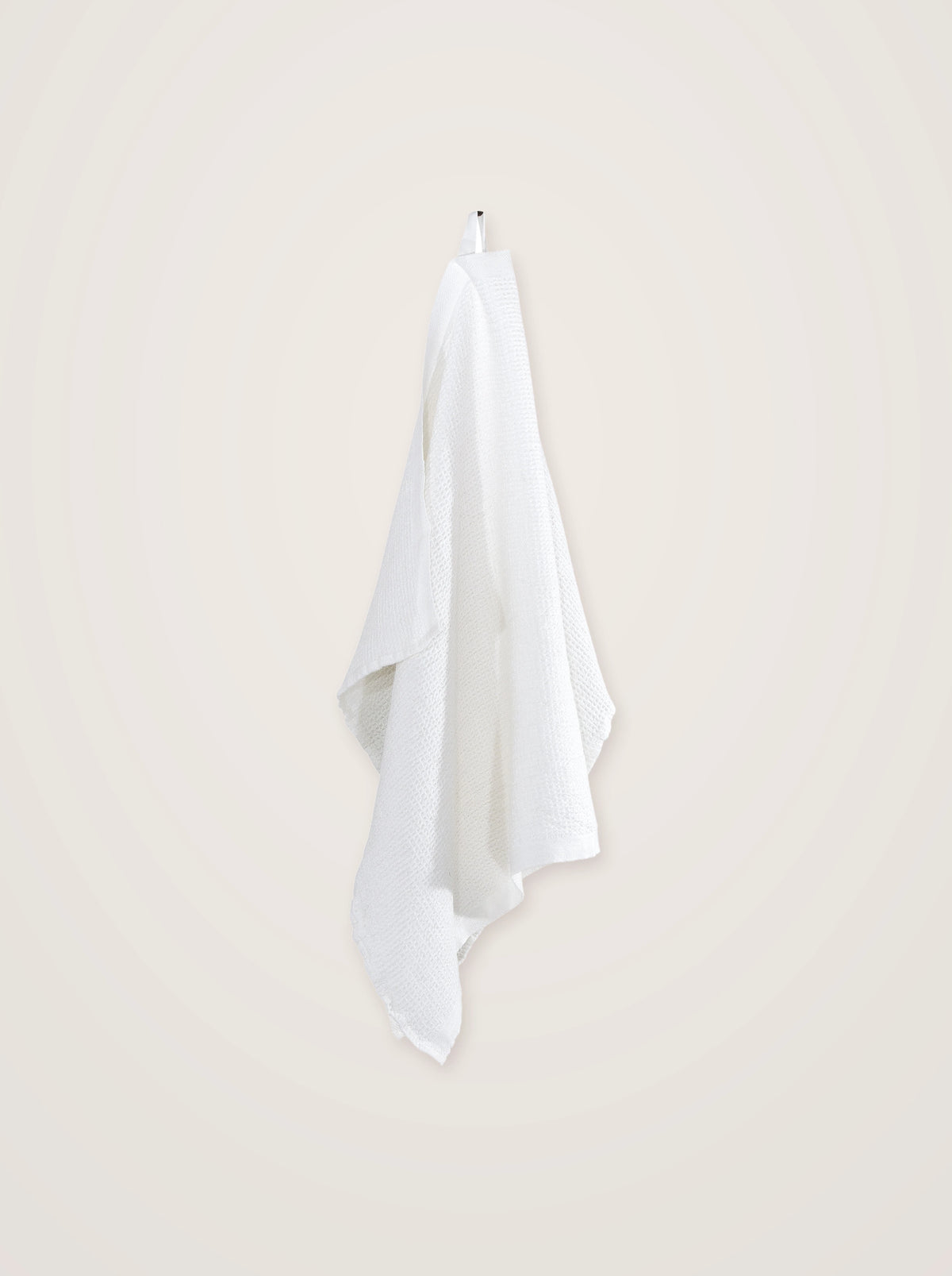 White linen-blend towel in a textured waffle weave hanging by its loop