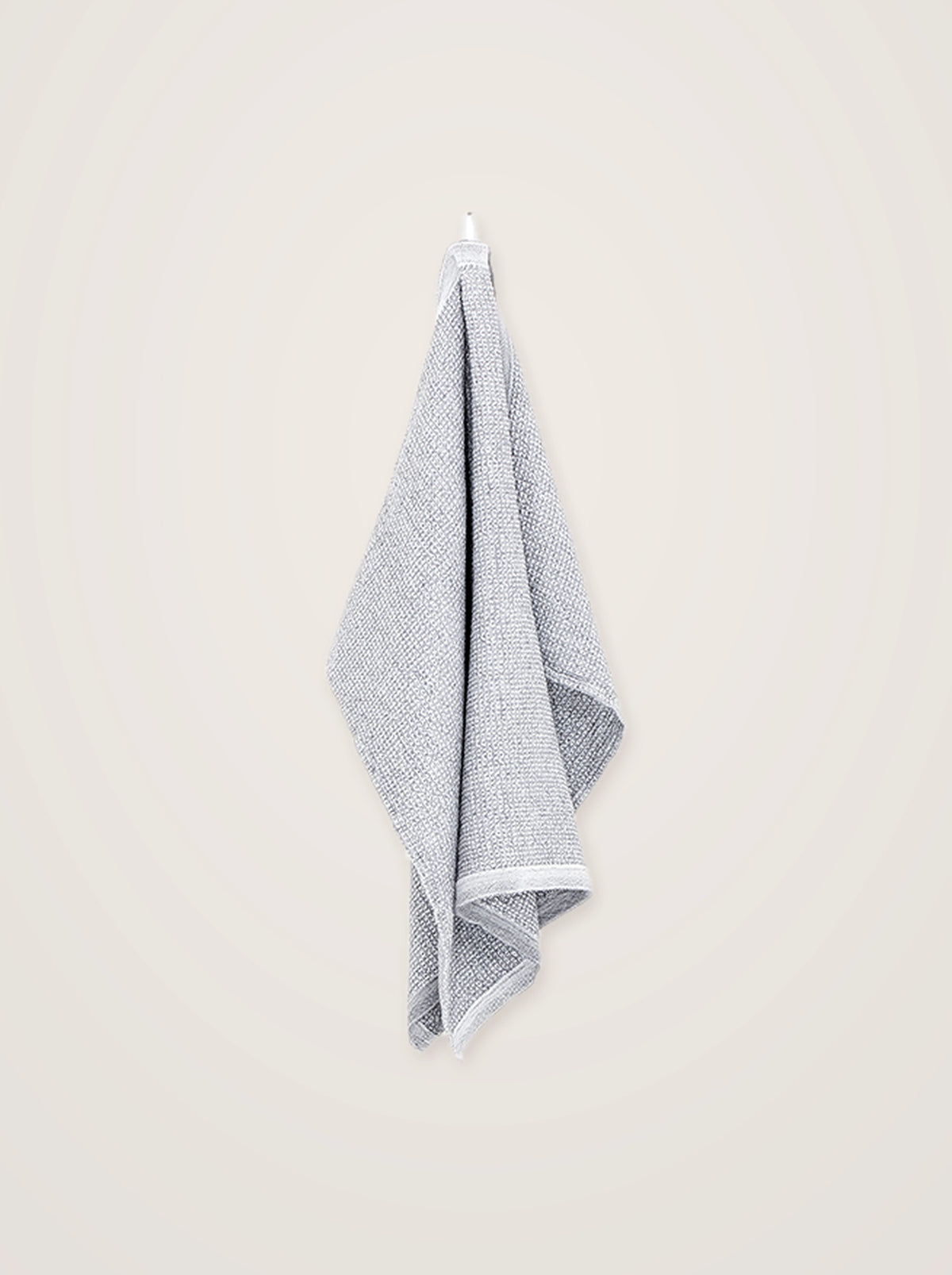 Two-tone white and grey waffle towel suspended from a hook, showing its full vertical drape
