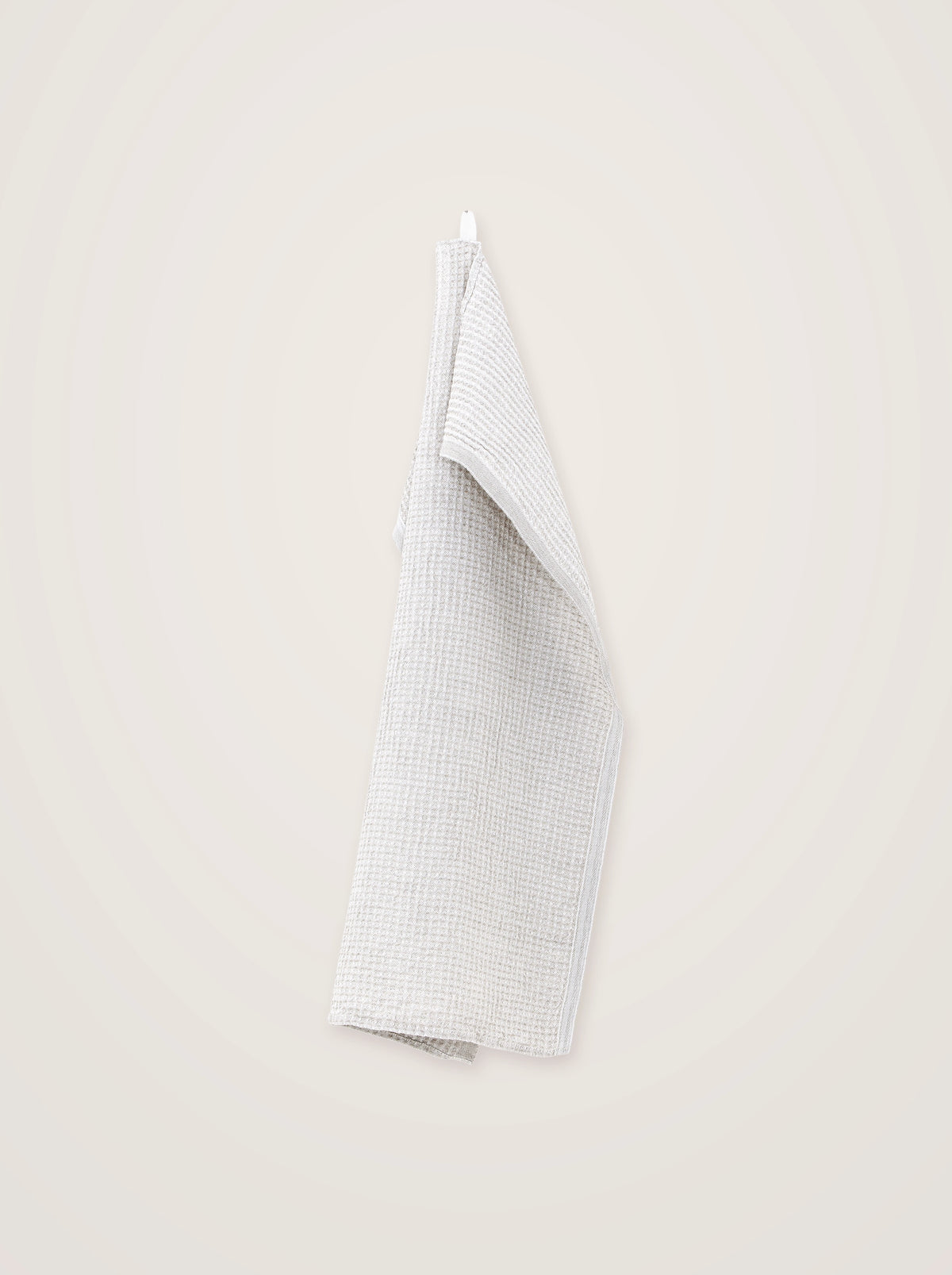 White linen-blend towel in a waffle weave with flat borders, draped from a hanging loop