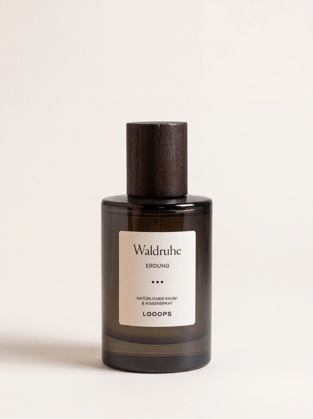 Waldruhe room spray in a cylindrical dark glass bottle with a stained ash wood cap