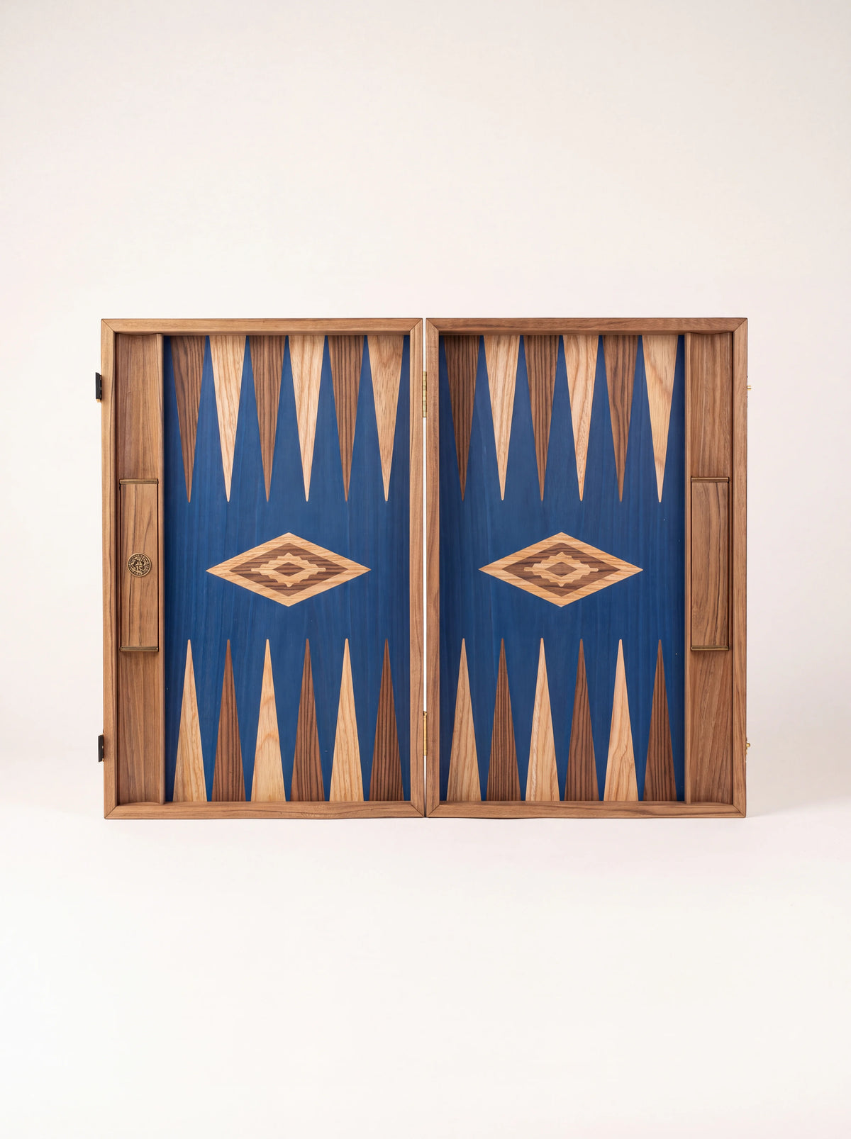 Empty blue oak backgammon board displayed open, showing inlaid points and diamond centrepieces