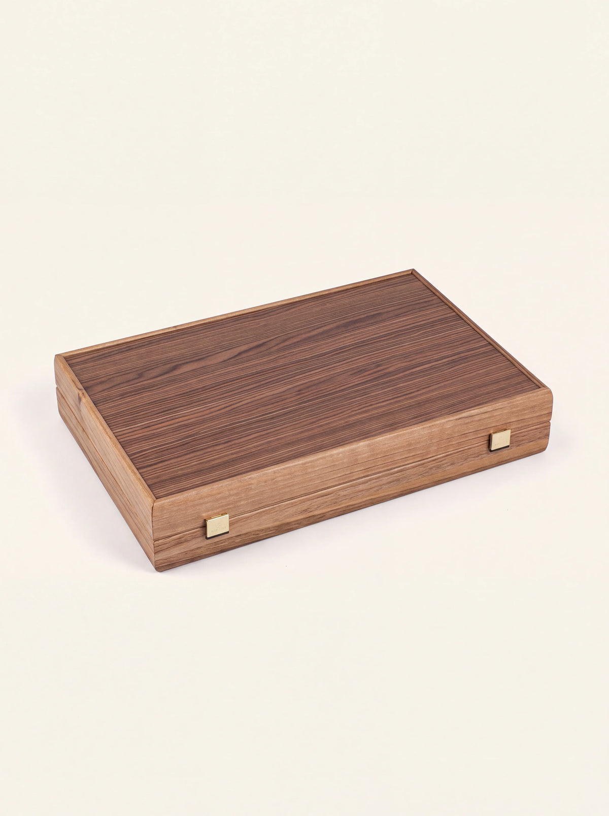 Closed walnut backgammon case showing the striped wood grain and two brass clasps