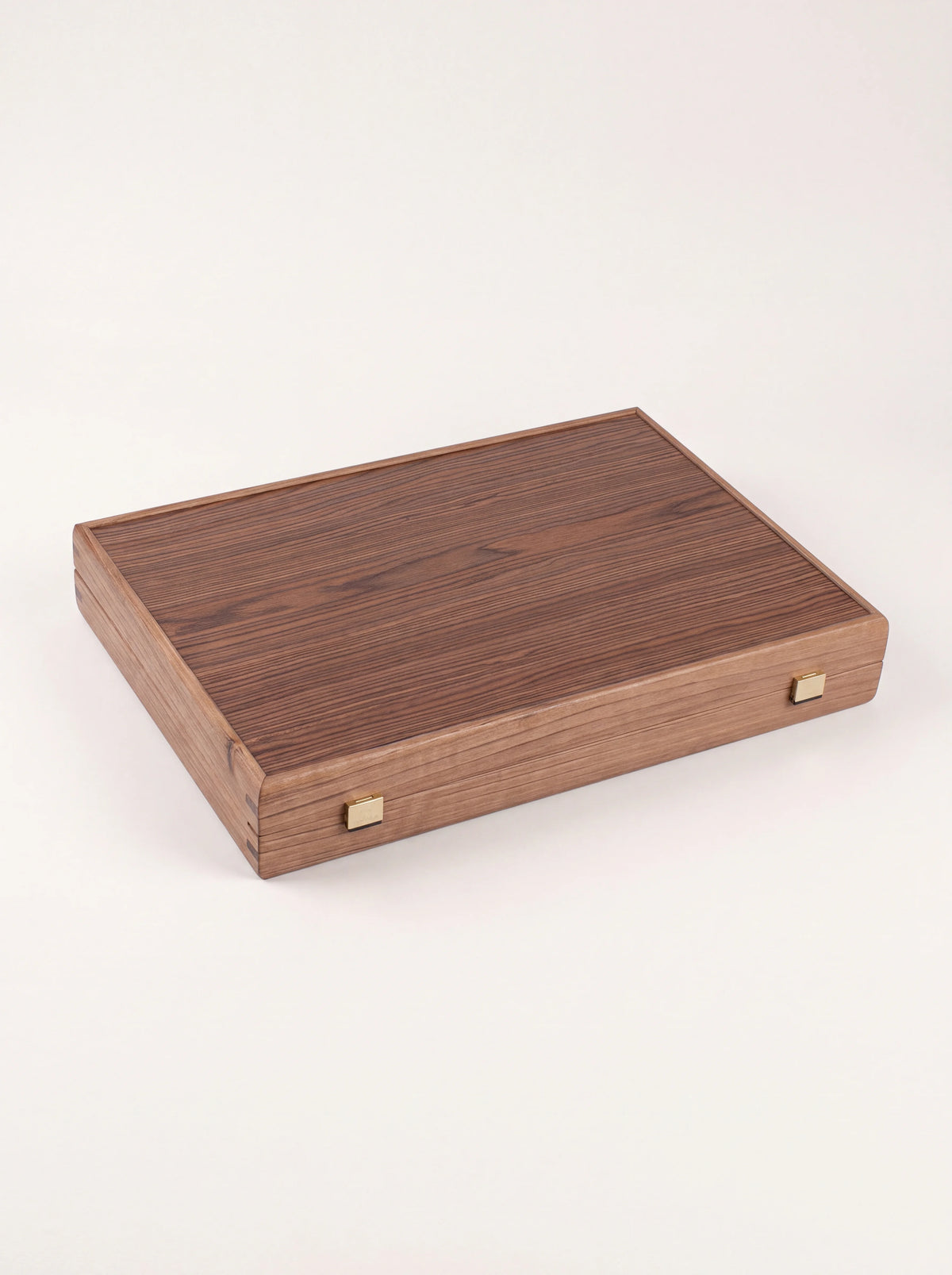Closed walnut wood backgammon case showing the exterior wood grain and two metal clasps