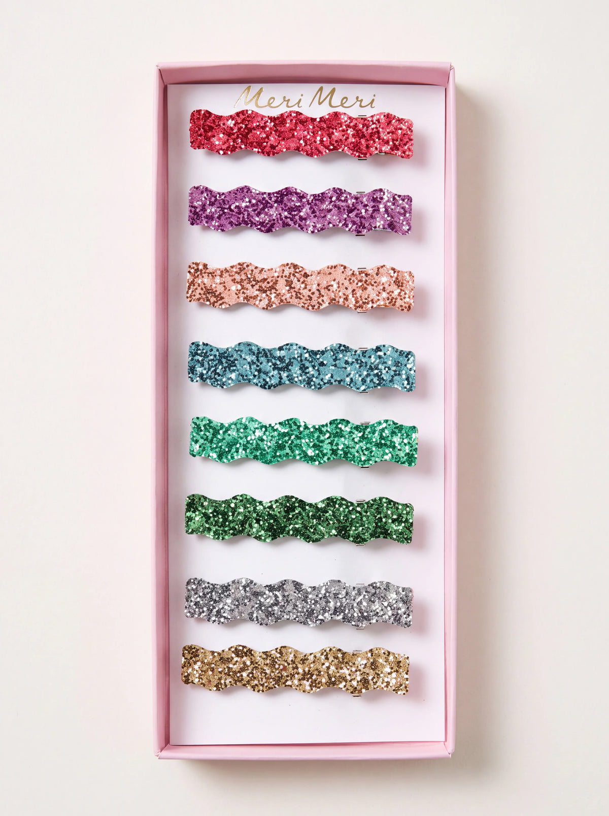 Wavy glitter hair clips in eight colours, displayed in a pink presentation box labelled Meri Meri