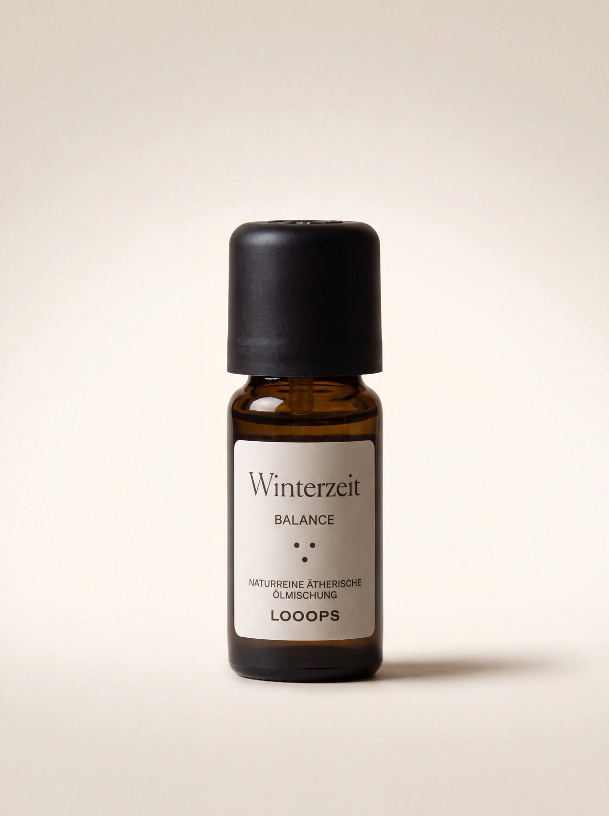 Winterzeit essential oil in an amber glass bottle with a black cap, labelled Winterzeit Balance