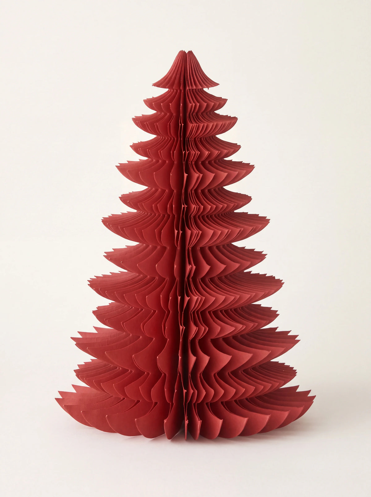 Ruby red paper tree decoration unfolded into a tiered honeycomb silhouette