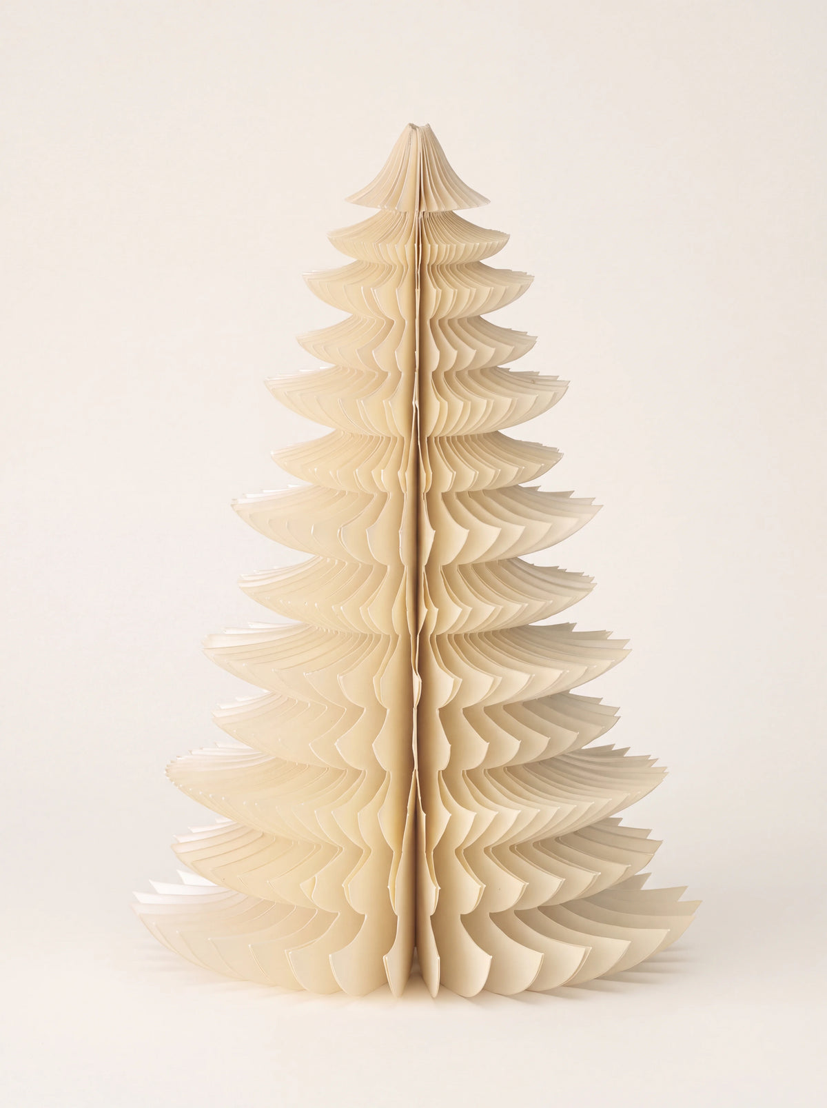 Cream-coloured paper Christmas tree decoration unfolded in a layered honeycomb structure