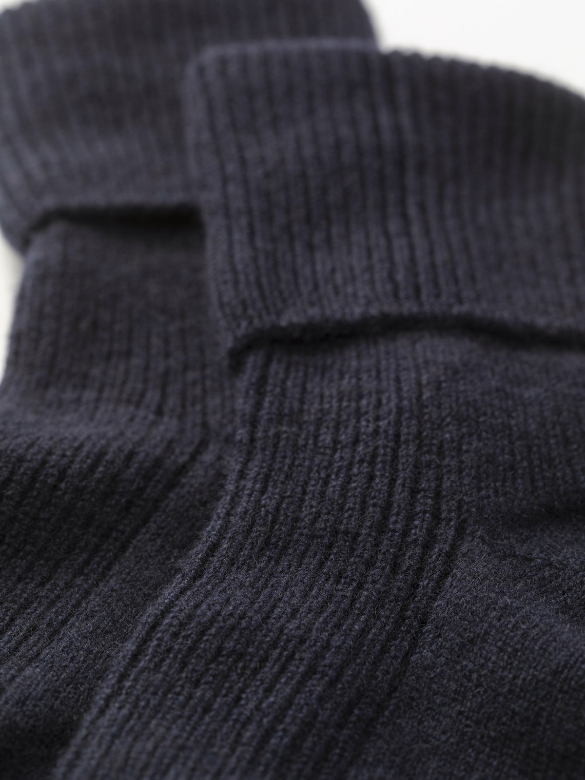 Close-up of the dark navy socks showing the ribbed cashmere knit texture and fold-over cuff