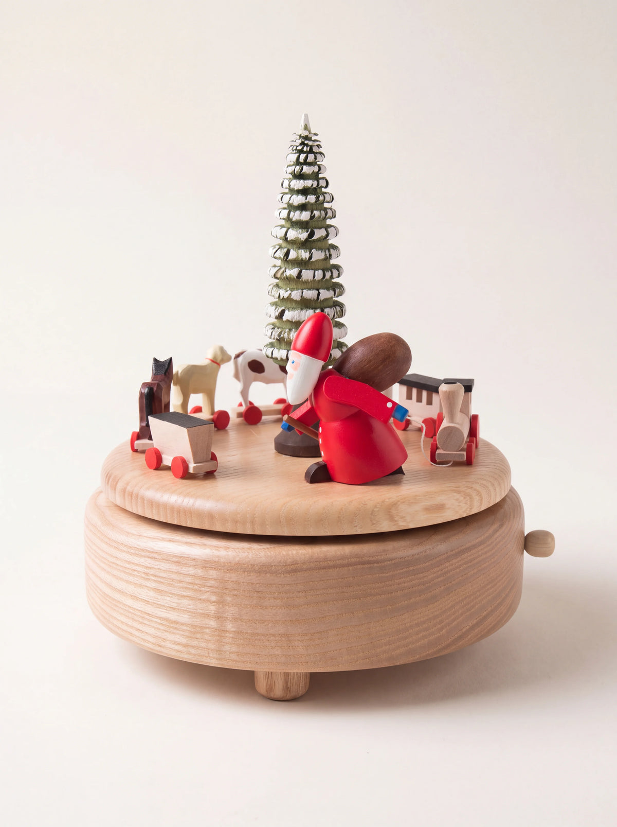 Round wooden music box featuring Santa Claus, a toy train and animals encircling a snowy central tree