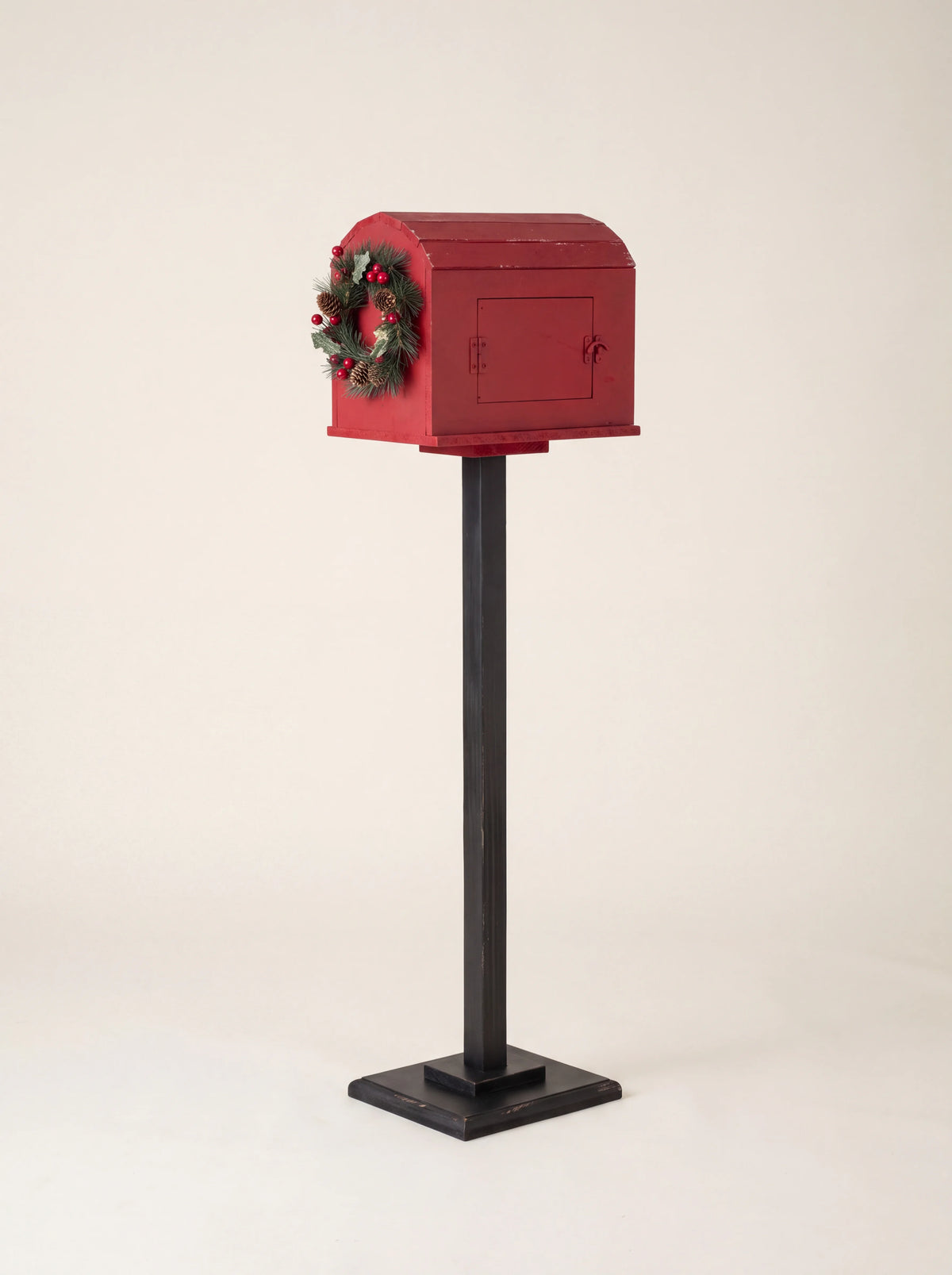 Reverse side of the red wooden post box showing the hinged side retrieval door with a latch
