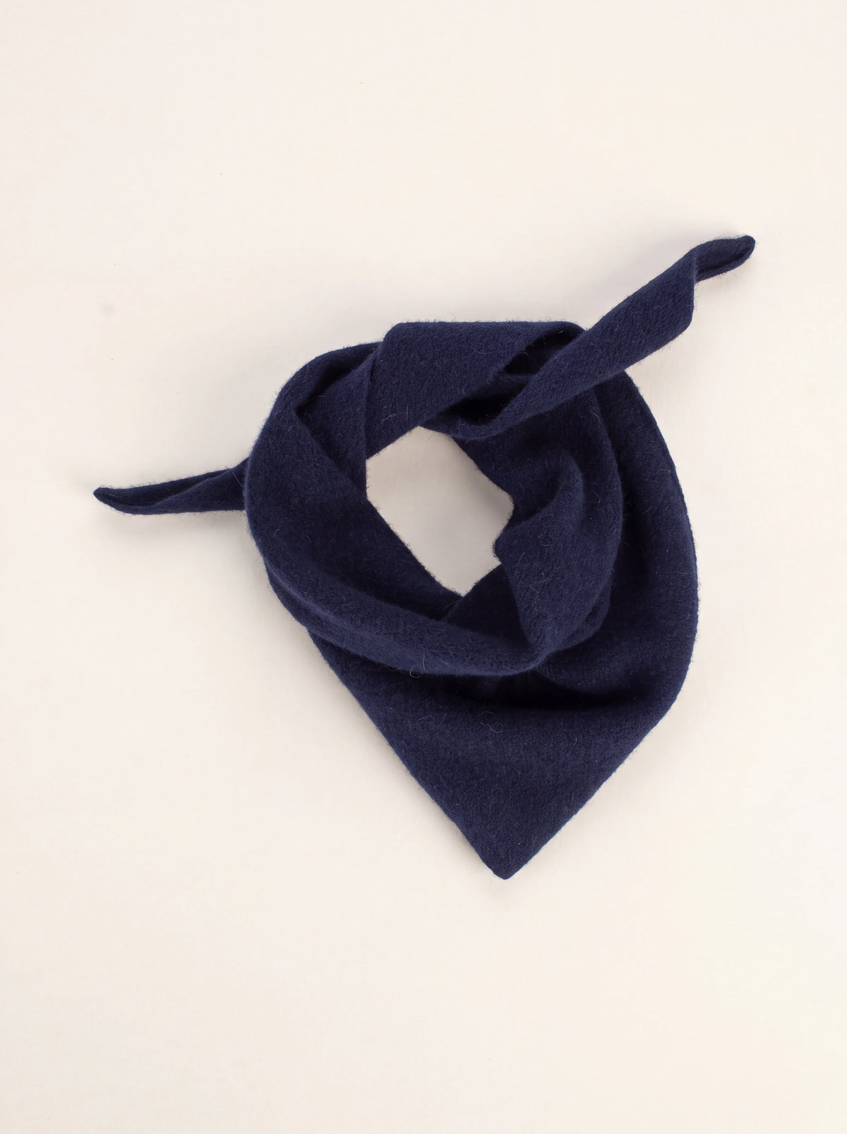 Midnight blue knitted wool bandana loosely arranged in a loop with tapered ends