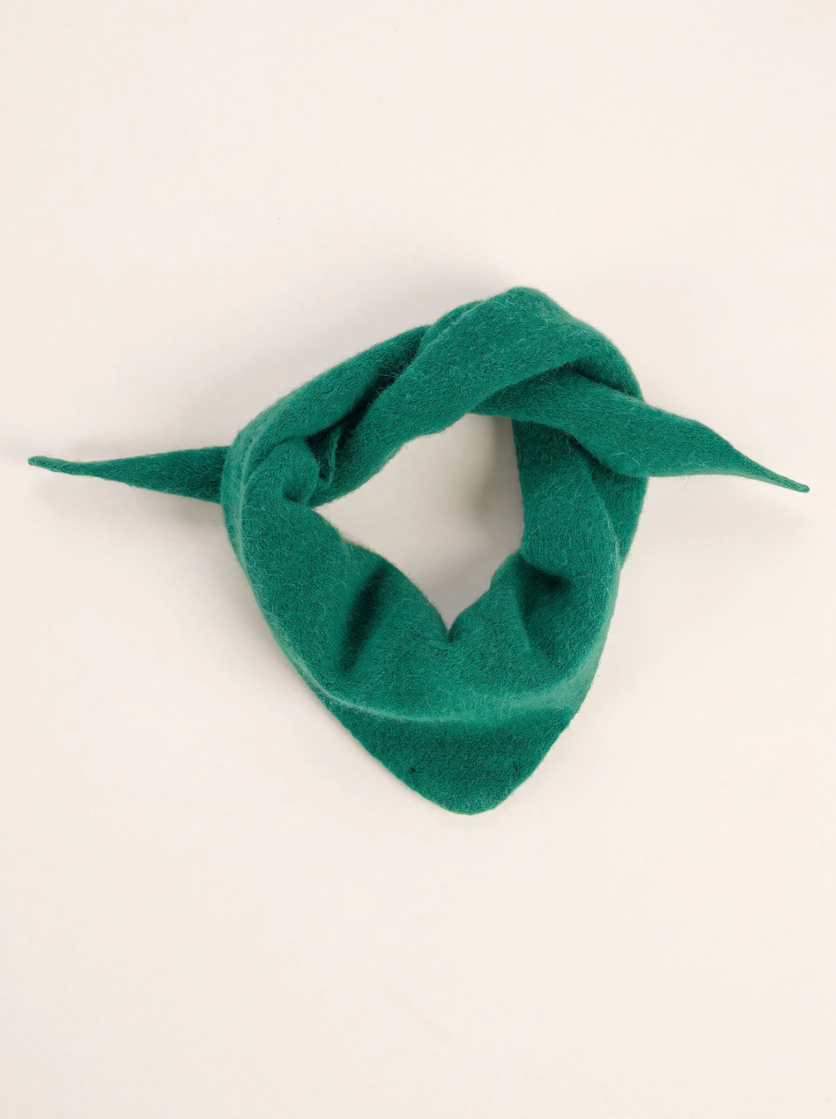 Pine green knitted wool bandana loosely knotted into a ring with tapered ends