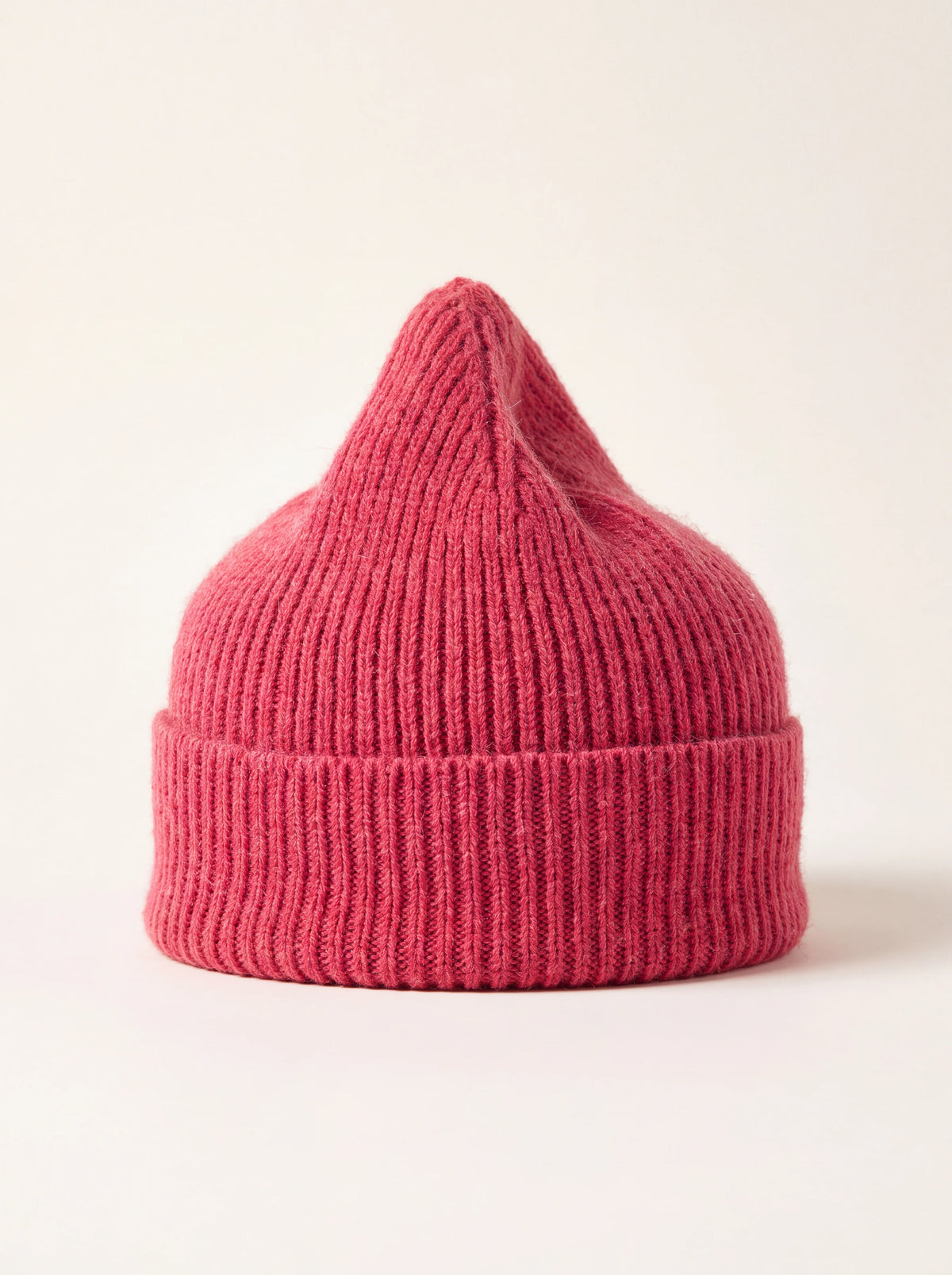 Ribbed fuchsia wool beanie with a folded turnover cuff and pointed crown
