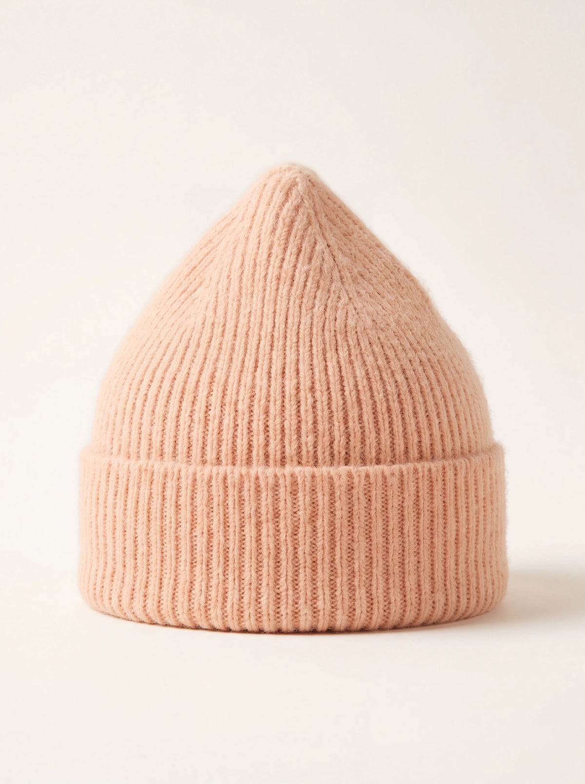 Peach ribbed lambswool beanie with a wide folded cuff and tapered crown