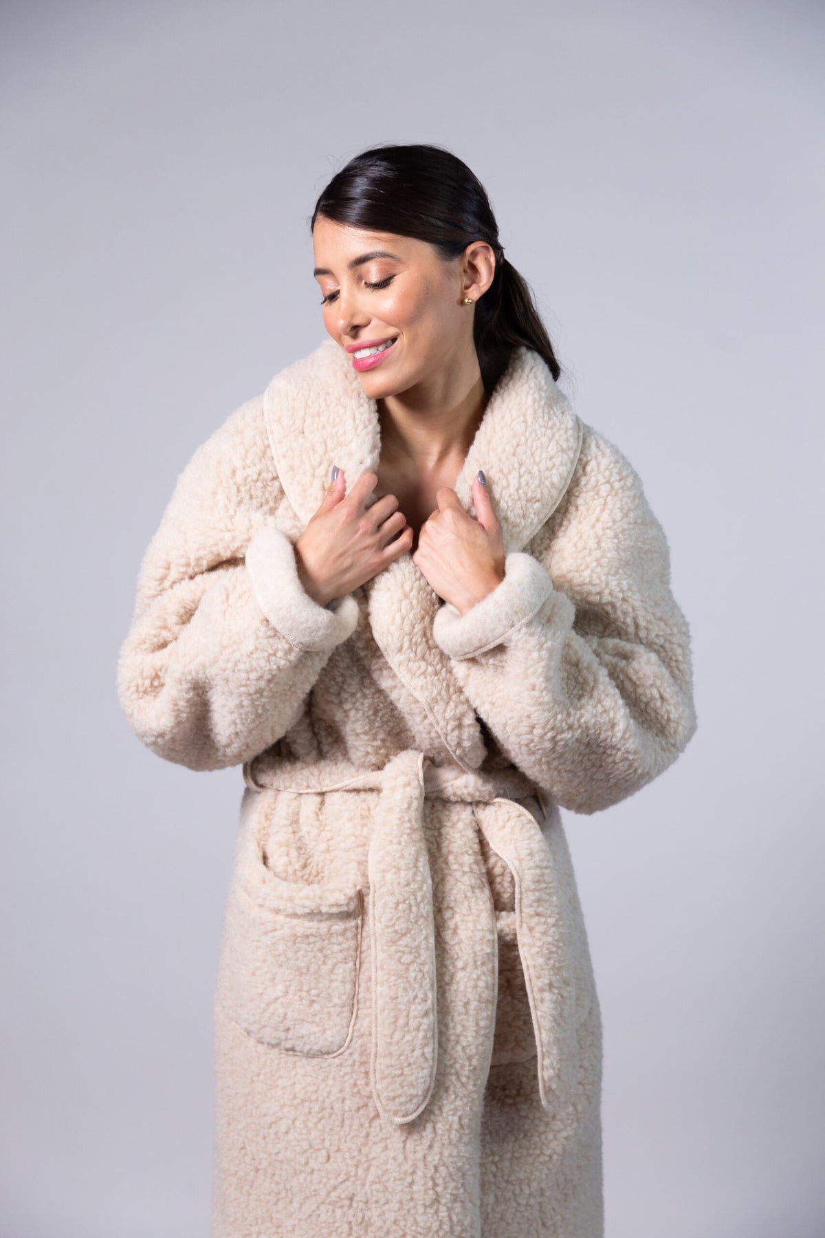 Beige sheep wool dressing gown with a shawl collar, belted waist and curly fleece texture