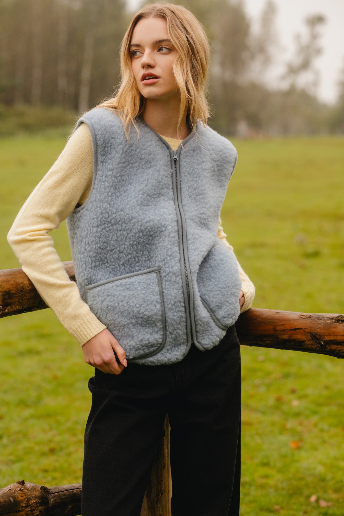 Icy blue wool fleece vest zipped closed, showing the collarless neckline and straight fit