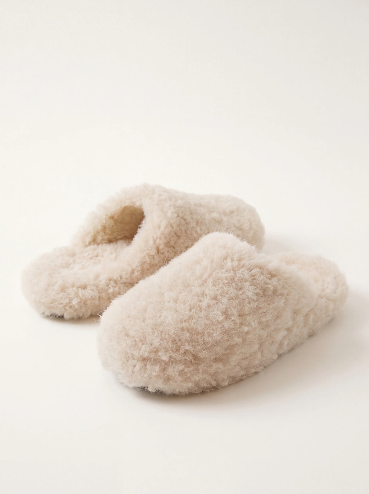 Beige sheep's wool mule slippers with rounded toes and open backs