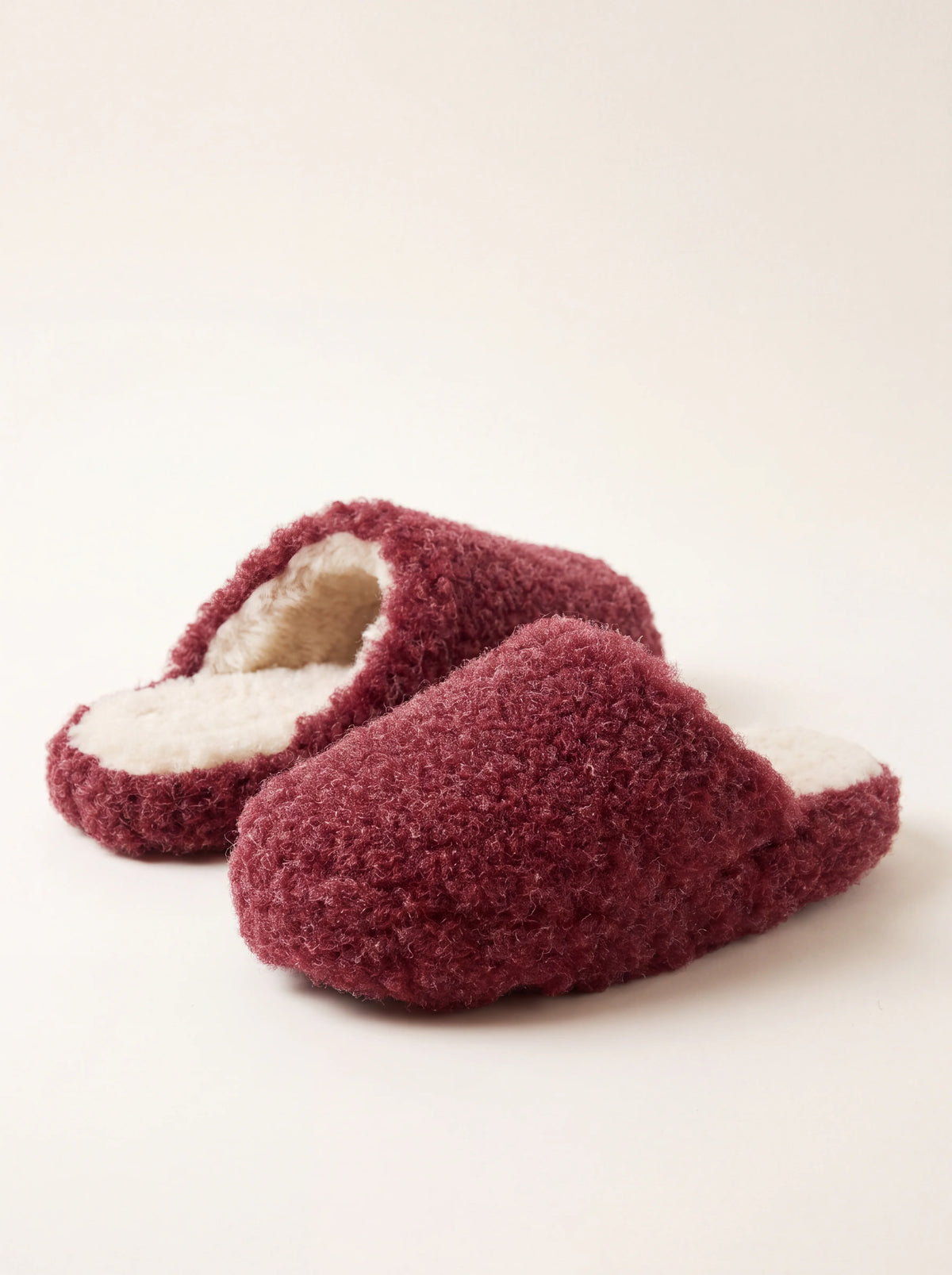 Dark red sheep wool mule slippers with a fluffy fleece exterior and cream lining