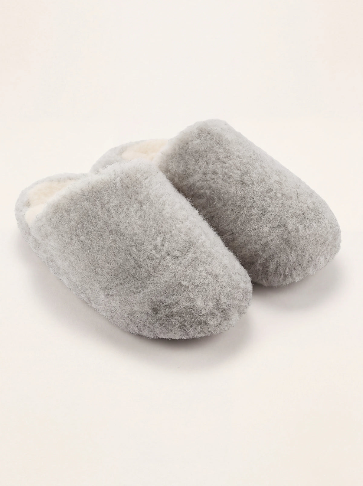 Light grey sheep wool mule slippers with a fluffy exterior and off-white fleece lining