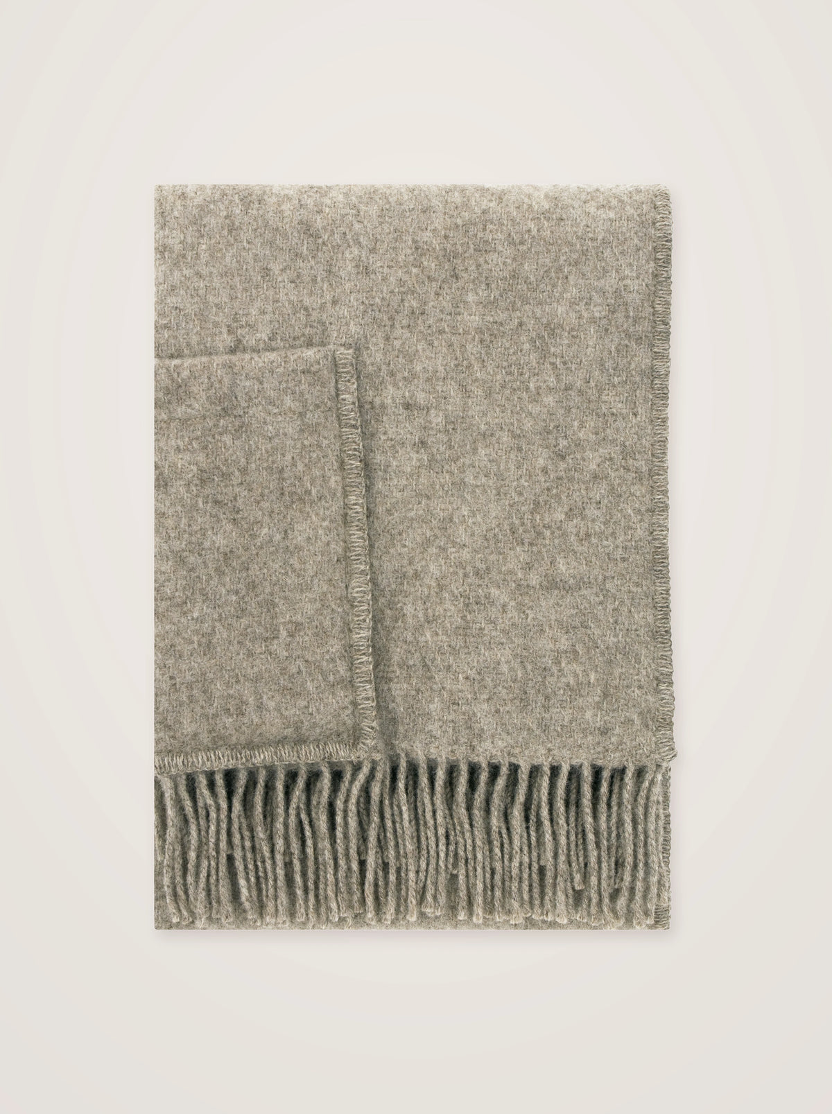 Melange beige wool pocket shawl folded flat, showing fringed trim and patch pocket