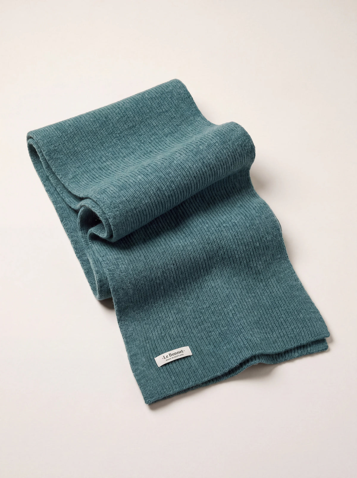 Rib-knitted wool scarf in basil green, folded with a woven label reading -Le Bonnet- MADE IN SCOTLAND