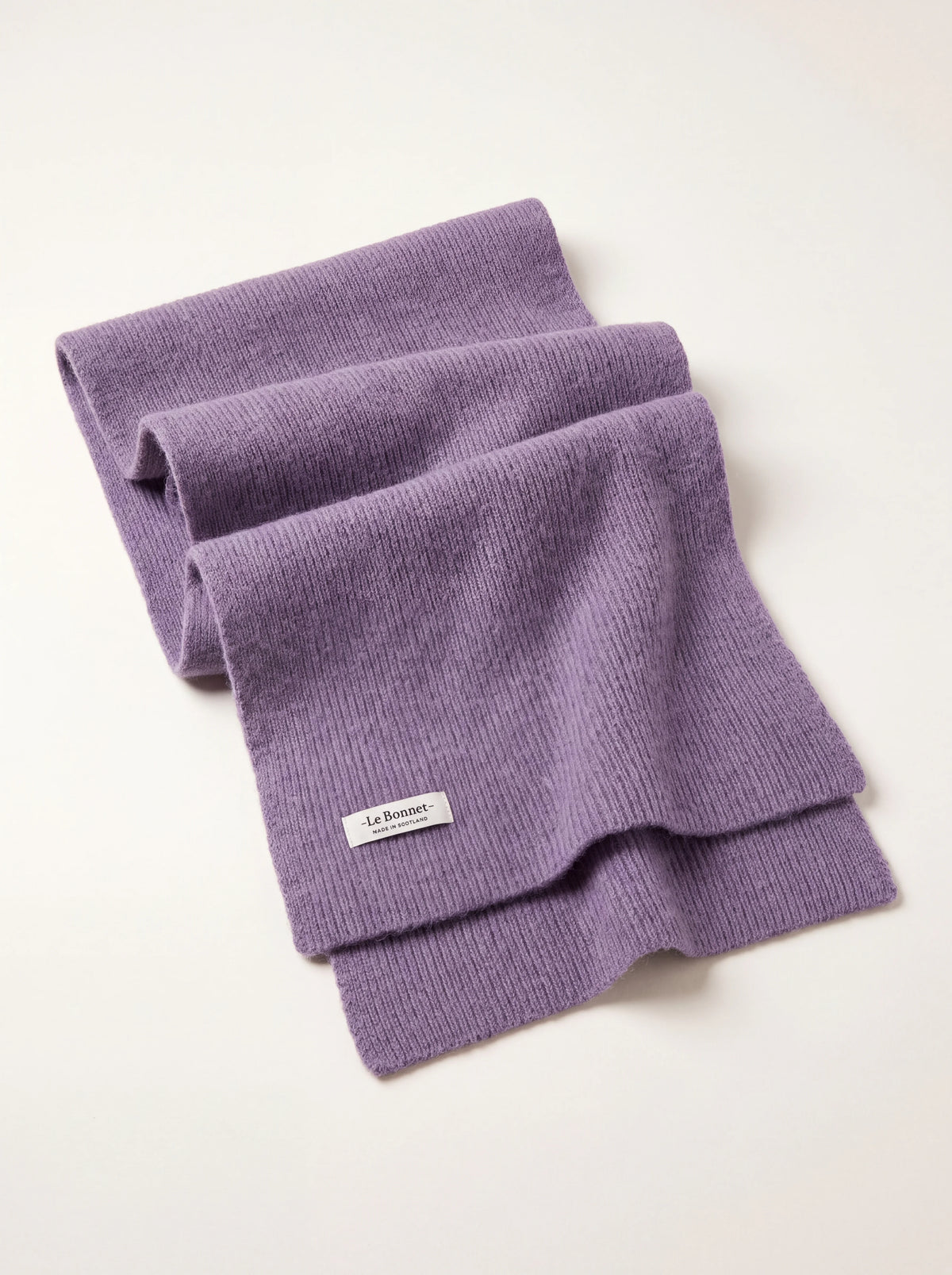 Lavender ribbed knit lambswool scarf, folded with a label reading -Le Bonnet- MADE IN SCOTLAND