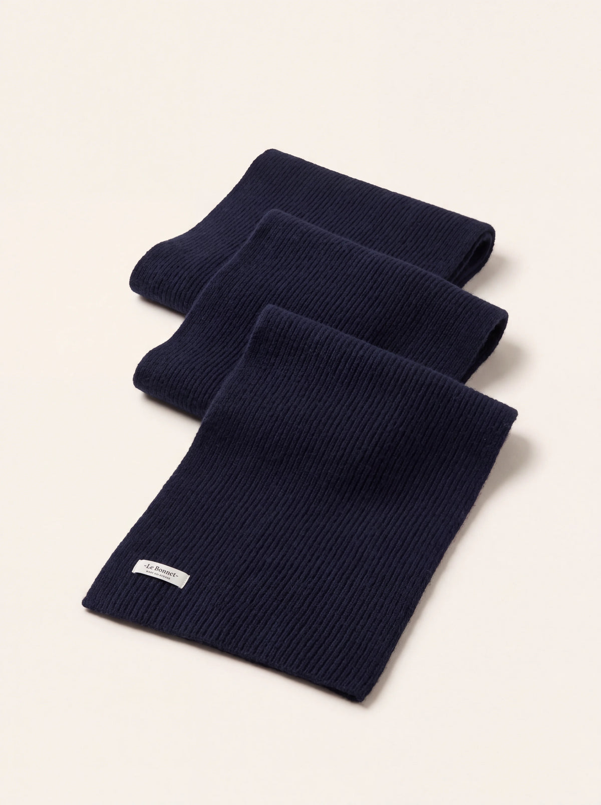 Ribbed lambswool scarf in midnight blue, folded with a sewn-in white label reading Le Bonnet