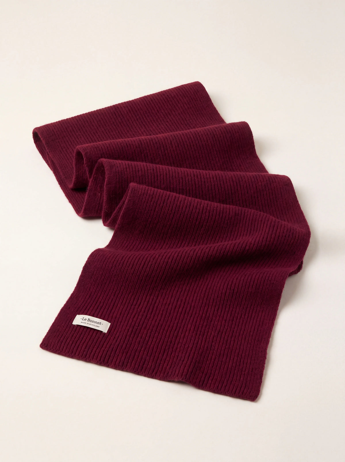 Ribbed wool scarf in wine red, folded with a white label reading -Le Bonnet- MADE IN SCOTLAND