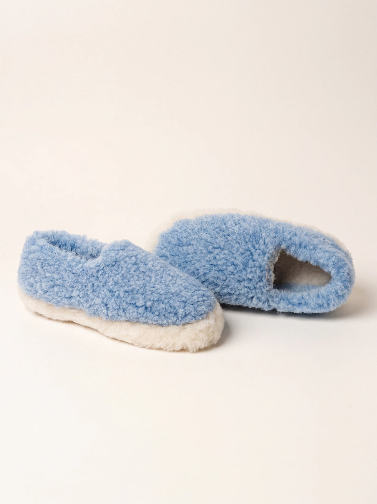 Light blue textured sheep wool slippers with a low ankle collar and fluffy off-white trim