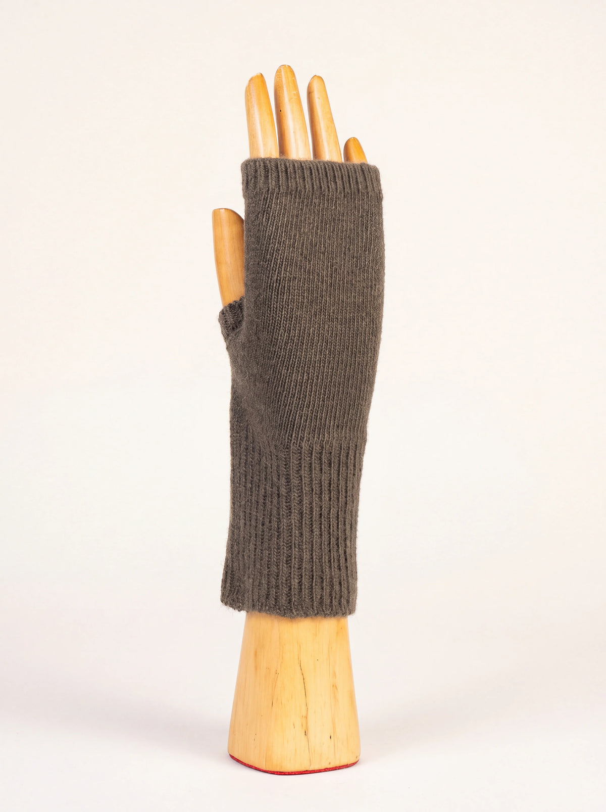 Grey wool and cashmere wrist warmer with a ribbed cuff and thumb opening, shown on a wooden mannequin hand