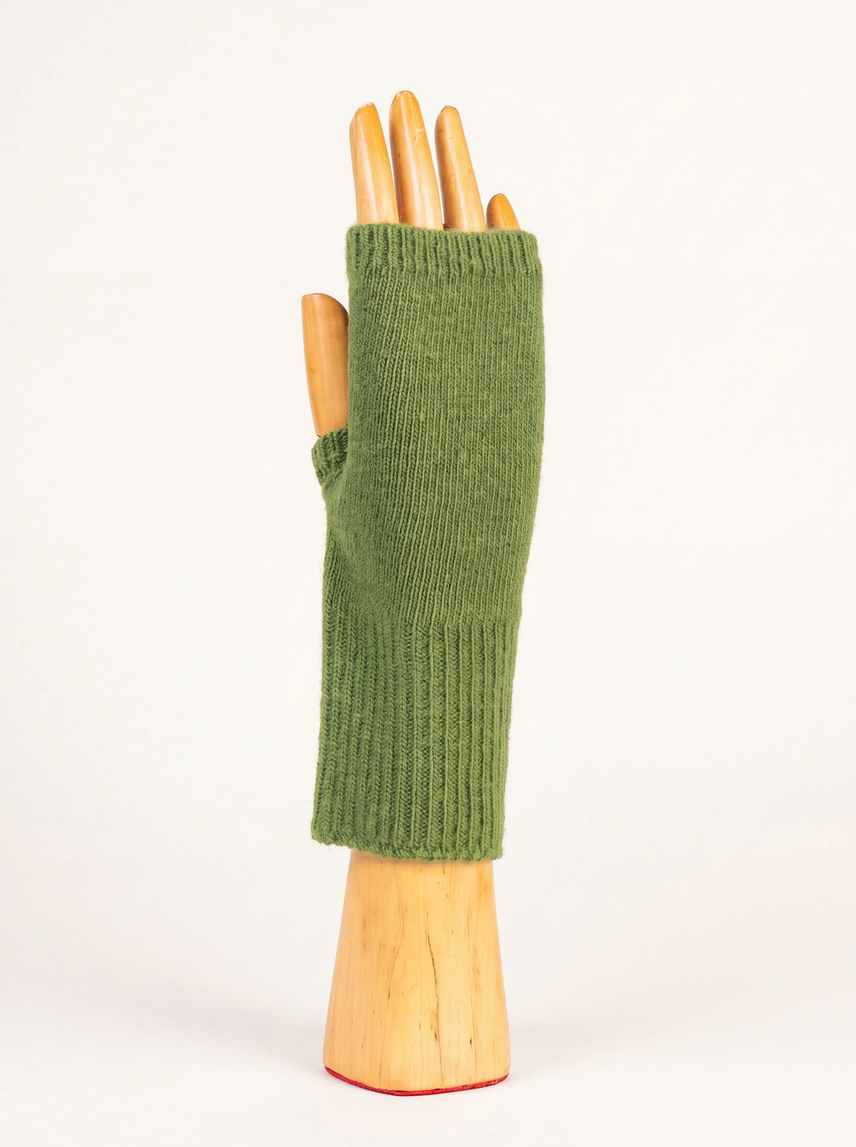 Cactus green knitted wool and cashmere wrist warmer with ribbed cuffs on a wooden hand