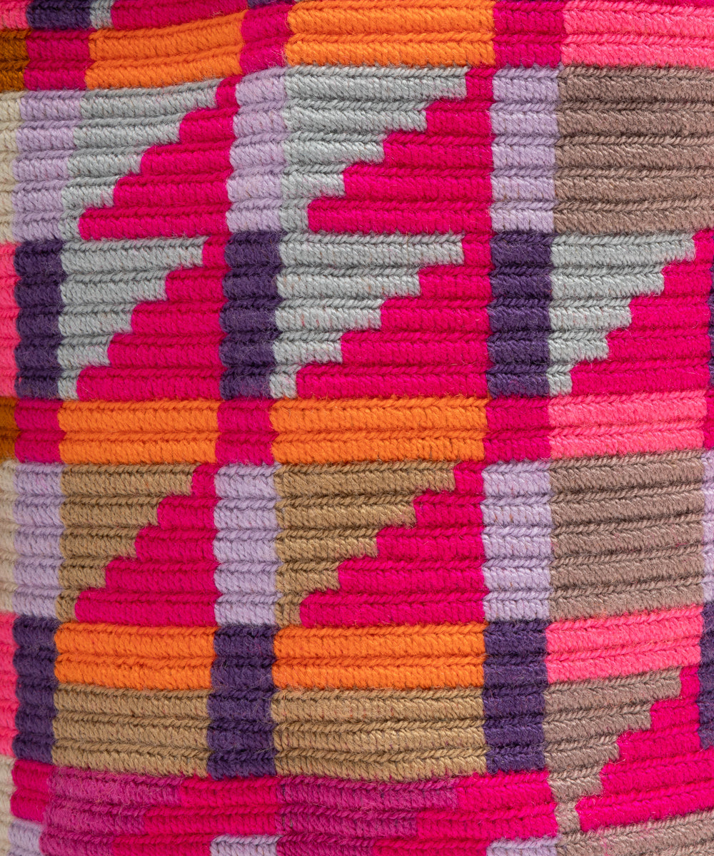 Close-up of the textured woven knit showing the geometric stepped pattern in fuchsia, purple and orange