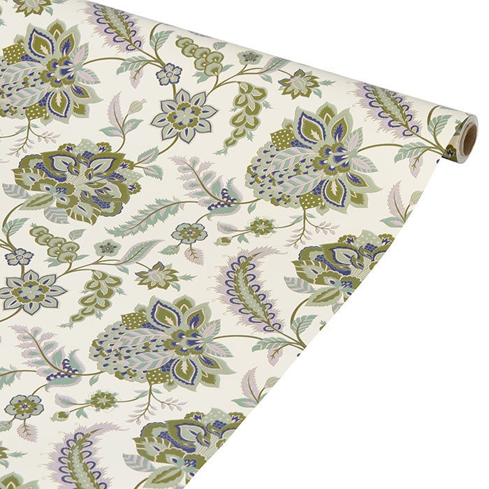 Roll of floral wrapping paper unrolled, patterned with botanical motifs in green, blue and purple on cream