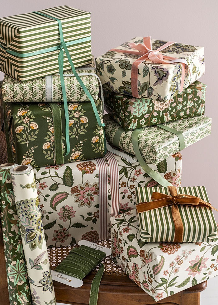 Stack of gift boxes wrapped in coordinating floral and striped papers with ribbons, shown with the paper roll